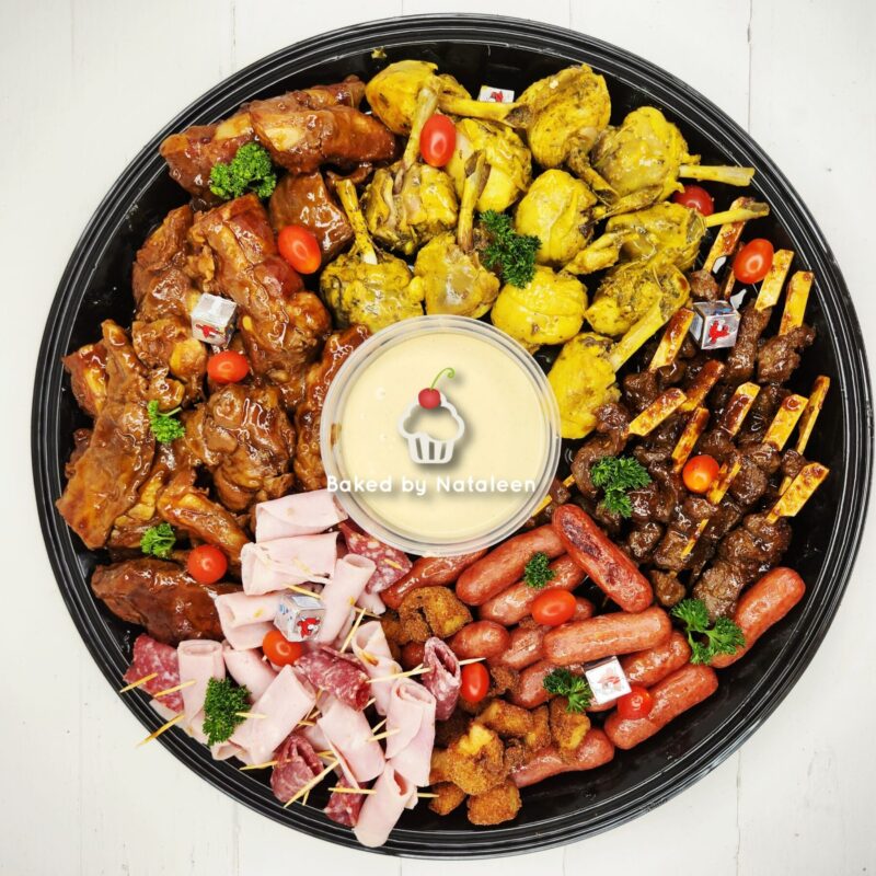 Large round platter of assorted appetizers around a central bowl of creamy dip labeled Baked by Nataleen, ready for sharing.