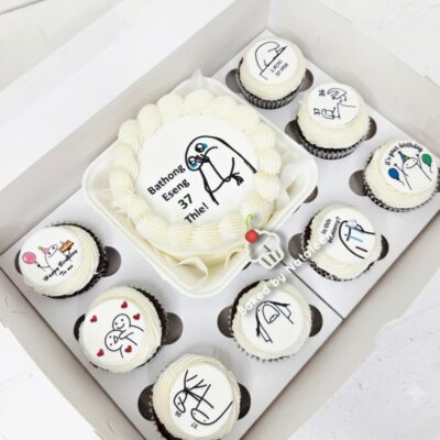 Cake set with a white iced round cake and several cupcakes, each with black line-drawn stick figures and small text; central cake reads a message in a non-English language.