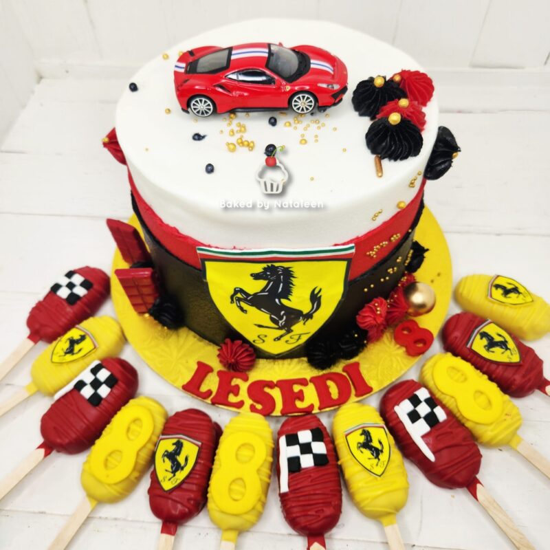 Ferrari-themed celebration cake with a red toy car on top, yellow and red panels, and a shield emblem on the side.