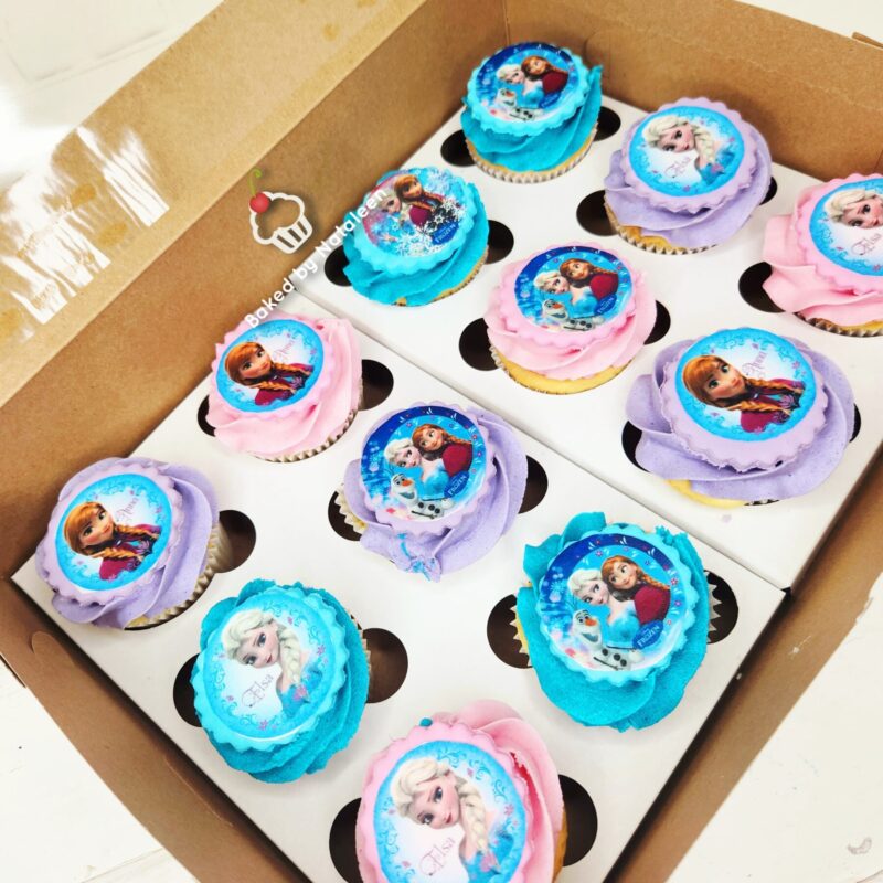 Box of Frozen-themed cupcakes with blue, pink, and purple swirled frosting and character toppers.