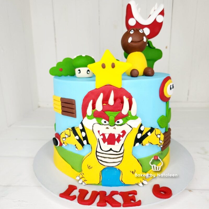 Mario-themed birthday cake with Bowser on the front, a yellow star on top, and 'LUKE 6' at the base.