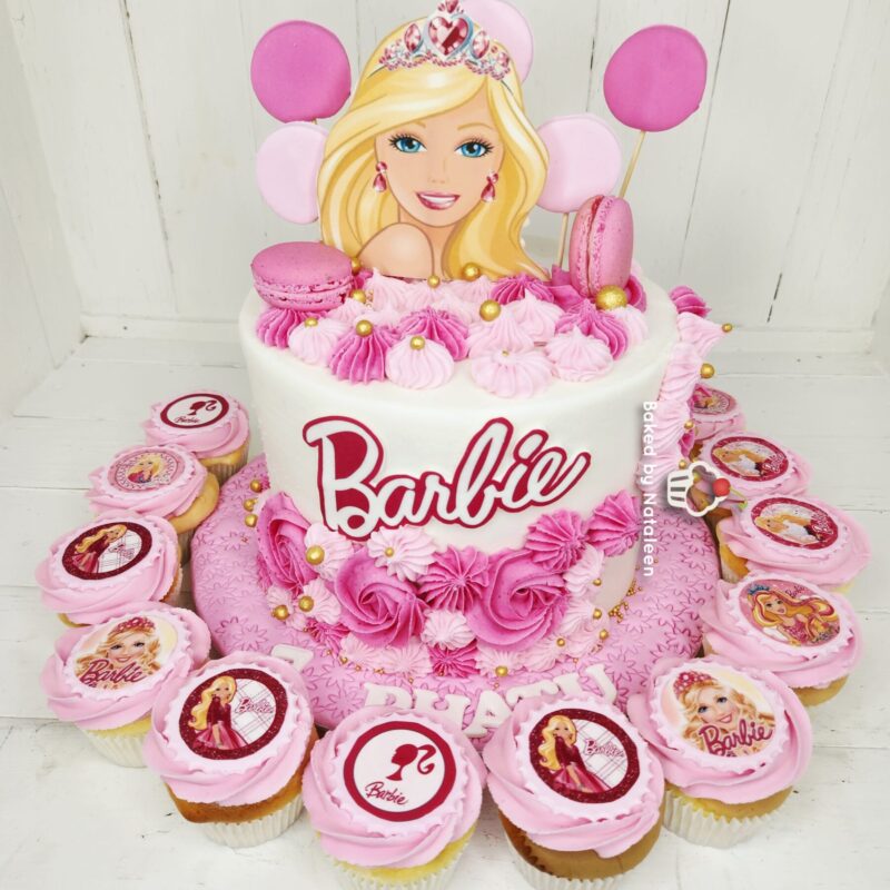 Barbie-themed birthday cake with pink frosting, a Barbie cutout topper, and matching cupcakes.