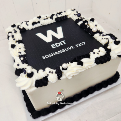 Rectangular white cake with a black top panel that reads 'W EDIT SOSHANGUVE 3257' and decorative black-and-white piping around the edge, plus a 'Baked by Nataleen' logo on the side.