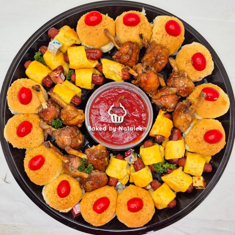 Platter of bite-size pastries arranged around a central cup of red dipping sauce; includes cheese cubes, nuts, and chicken wings.