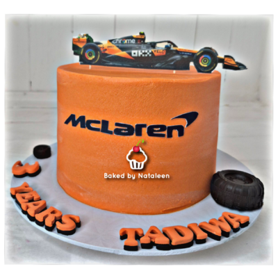 Orange McLaren-themed cake with a toy Formula One car topper and 'Baked by Nataleen' label