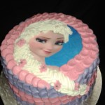Round Frozen theme birthday cake with edible printed topper and frosted braid