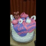 Baby shower cake: white wicker basket with pink and purple fondant blanket and "baby stuff" toppers